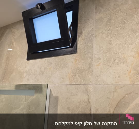 חלון אלומיניום קטן פתוח בקיר אמבטיה